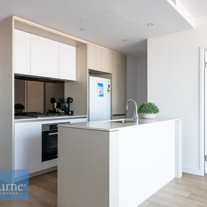 angeld view of kitchen with glass splashback and fridge